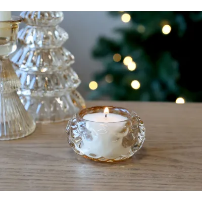 Photophore en verre ambré allumé, ambiance festive.